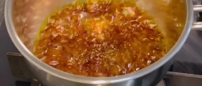 Add water slowly to the caramel, stirring to combine. Pour into the mold, coating the bottom evenly.