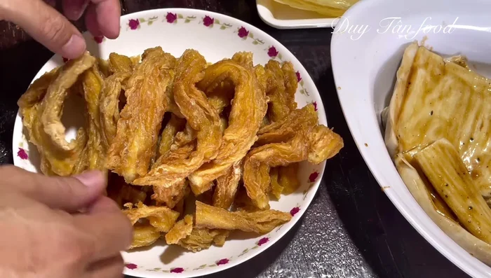 Cut Cao hu ki stems into pieces equal to the length of the mushroom. Cut off the stiff outer edge of Tofu ki leaves for easier rolling.