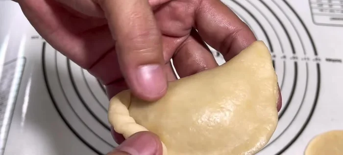 Add a spoonful of filling and an optional half quail egg to the center of each circle. Fold the dough over to enclose the filling, pinching the edges to seal. Flatten the dough slightly.