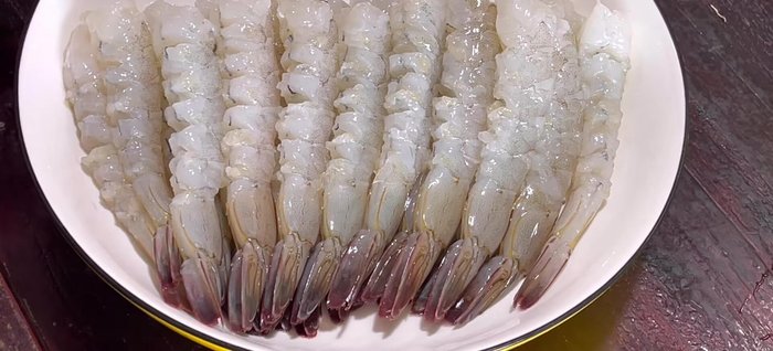 Clean, peel, and devein shrimp, leaving the last segment and tail. Wash with diluted saltwater and pat dry. Make small cuts on the shrimp belly to prevent shrinking during frying.