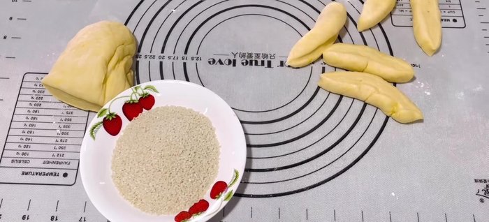 Prepare Sesame Seeds: Flip each dough portion inside out. This makes it easier to coat in sesame seeds.