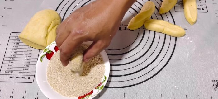 Coat and Rest: Roll each dough ball into a flat oval shape, pressing lightly. Coat evenly with sesame seeds. Cover and let rest for 10-15 minutes.
