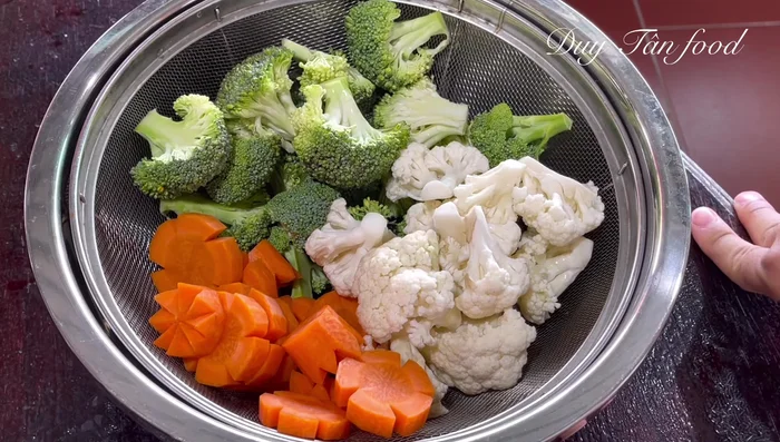 Prepare vegetables: Blanch carrots, broccoli, and cauliflower. Add a teaspoon of salt to the boiling water. Prepare ice water to quickly cool the vegetables after blanching.