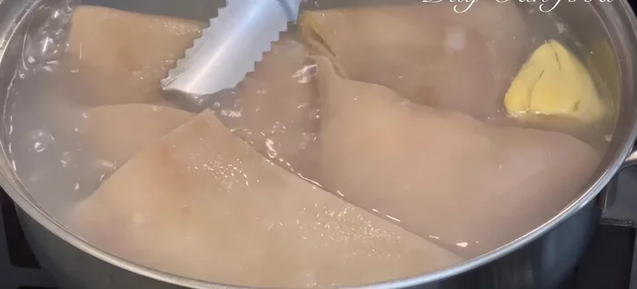 Once the pork skin is soft, immediately transfer it to a bowl of ice water to firm it up. Then, soak it for 5-10 minutes in cold water, rinse and drain. Cut into strips (about 0.5cm thick).