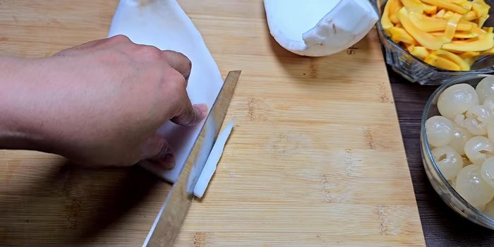 Prepare the young coconut meat: Cut thinly (165.48). Mix with 50g of sugar to allow it to absorb (185.04).