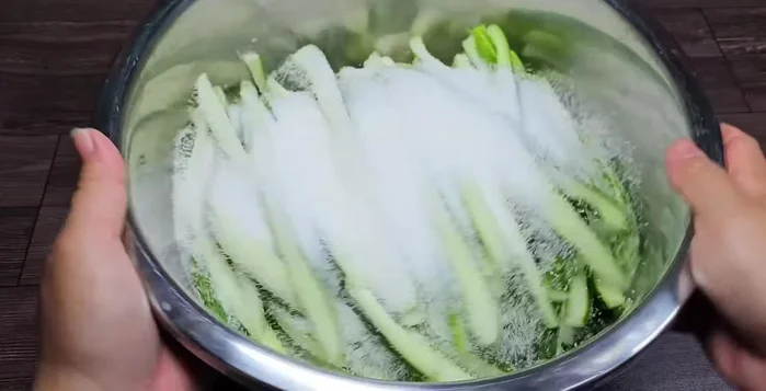 In a bowl, toss the cucumber pieces with 200g of sugar. Let it sit to soften and release excess water. This method helps to keep the cucumbers crispy and less salty.