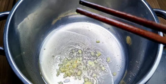 Heat oil in a pot. Add garlic and shallots to deodorize. Then, add the marinated pork intestines and stir-fry.
