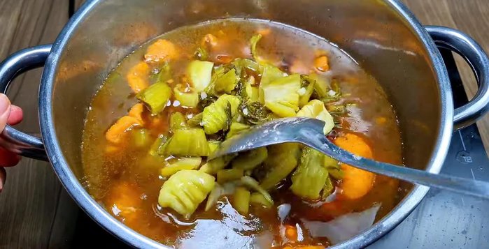 Add the stir-fried sour cabbage to the pot. Continue to simmer on medium heat for another 20 minutes until the cabbage is soft. Skim off any foam as needed.