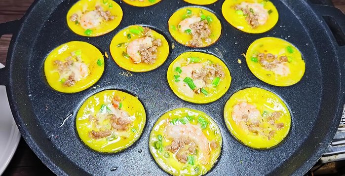 Cook over medium heat with the lid on until the batter is cooked and the shrimp are cooked through. Remove the cooked banh khot and repeat with the remaining batter.
