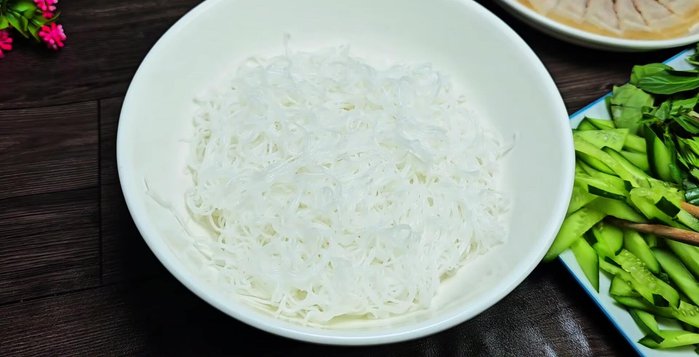 Prepare the vermicelli bowl: Arrange vermicelli, cucumber, lettuce, and other vegetables in a bowl. Add fried onions and roasted peanuts.
