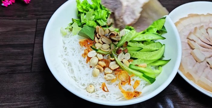 Add sliced pork belly and pour fish sauce over the vermicelli.