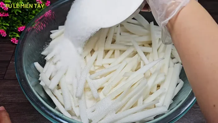 Soak the radish: In a large basin, combine the radish with 300g of sugar and let it sit for 2-3 hours to release water and reduce pungency.