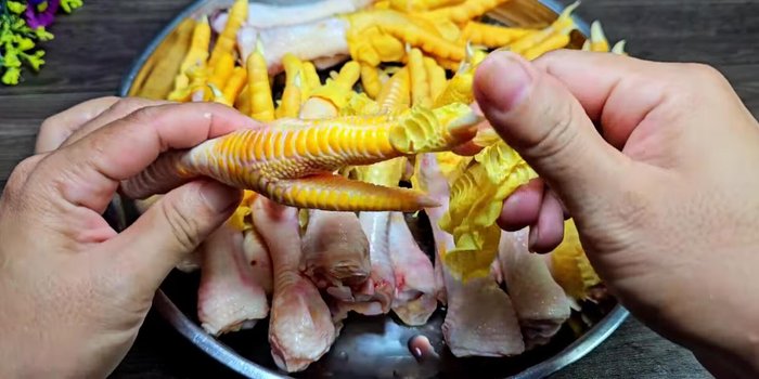 Peel off the outer skin of the chicken feet and remove the nails using scissors.