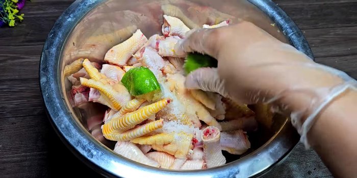 Cut the chicken feet in half. Add 2 tablespoons of salt and a lemon (including peel) to the chicken feet. Squeeze the chicken feet to release impurities and rinse thoroughly.