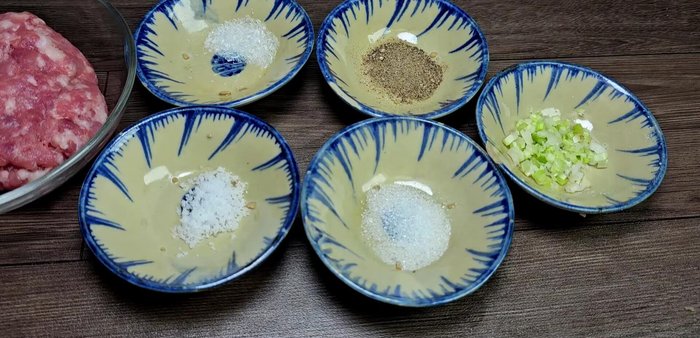 Prepare the minced meat: Marinate 200g of minced meat (slightly fattier for juiciness) with 1/3 teaspoon MSG, 1/3 teaspoon salt, 1/3 teaspoon sugar, a little chopped green onion root, and 1/2 teaspoon pepper. Mix well.