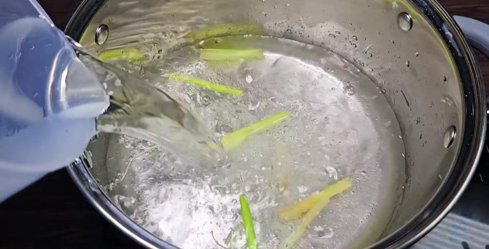 Add 2 liters of water and 100g of tamarind pulp to the pot. Mash the tamarind to extract juice.