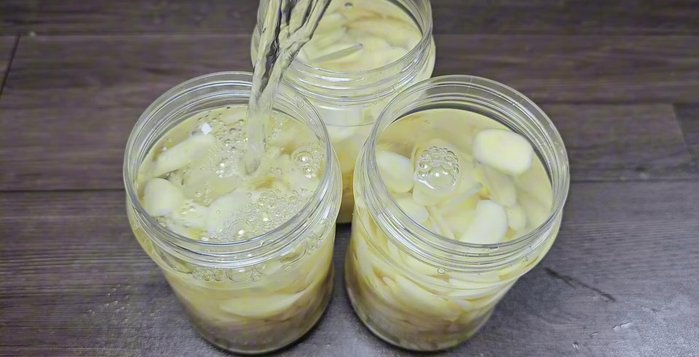 Pour the cooled pickling liquid over the garlic, ensuring it's fully submerged. Stir gently.