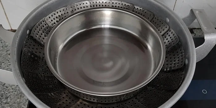 Grease an 18cm cake mold and preheat the steamer.