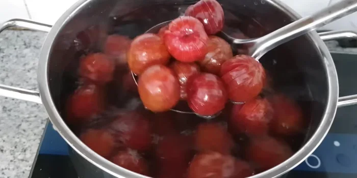 Rinse the boiled plums with water and drain (85.89).