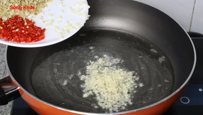 Stir-fry shrimp paste in the remaining pork fat. Add garlic and fry until golden and fragrant.