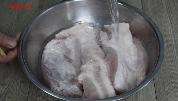 Blanch the pork belly in boiling water to clean and firm it. Then roughly chop it.