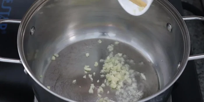 Heat oil in a pot and stir-fry the remaining minced garlic until firm. Add the chopped ginger and stir-fry until fragrant.