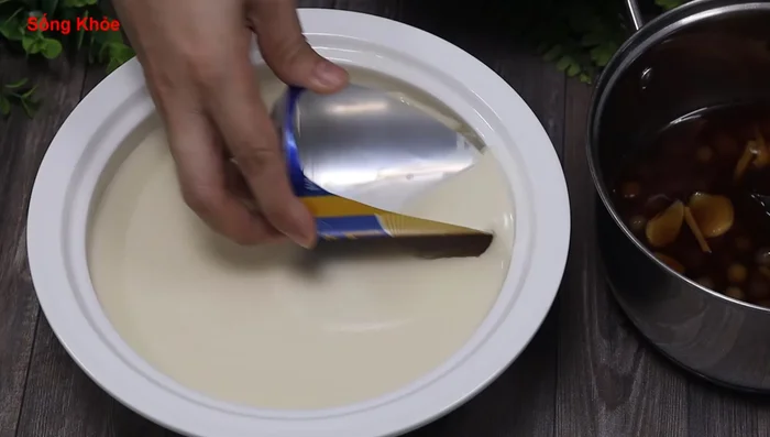 Once the tofu has solidified, scoop it out using a spoon or a beer can opener. Pour the sugar water and tapioca pearls over the tofu.