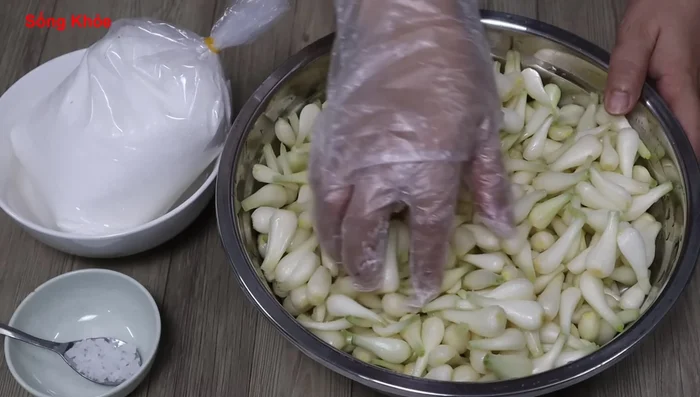 Combine the Kiệu with 700g of sugar and 1 teaspoon of salt (or 2 teaspoons if you didn't pre-soak in salt). Mix well.