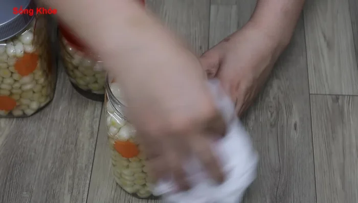 Press down the Kiệu to ensure they are fully submerged in the sugar mixture. Cover the jar and let it soak for 2 weeks. If sunny, air dry for faster pickling process.