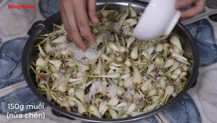 Add 2 tablespoons (40g) of salt and tapioca starch to the Kiệu mixture. Add enough water to cover everything.