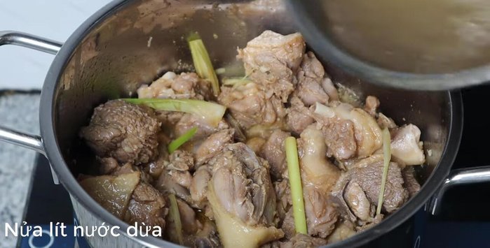 Add half a liter of coconut water (gradually), scraping the marinade from the bowl into the pot. Add the remaining crushed lemongrass.