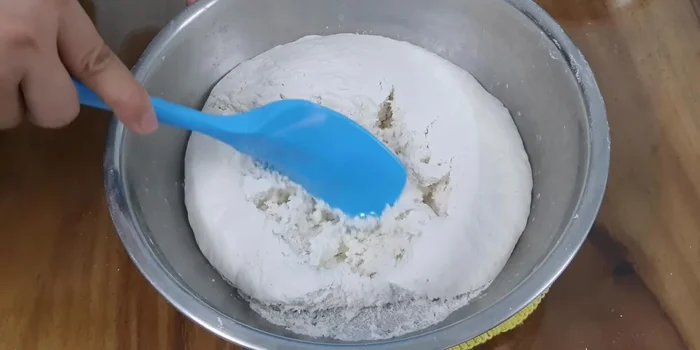 Once the dough has risen, add the cooled sugar-coconut milk mixture and vanilla extract. Mix well.