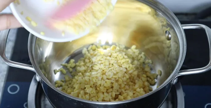 Cook mung beans with enough water to cover them until soft. Skim off foam, then reduce heat to low and cook until water dries up.
