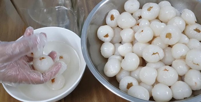 Gently add the peeled lychees to the cooled sugar syrup, ensuring they are fully submerged.