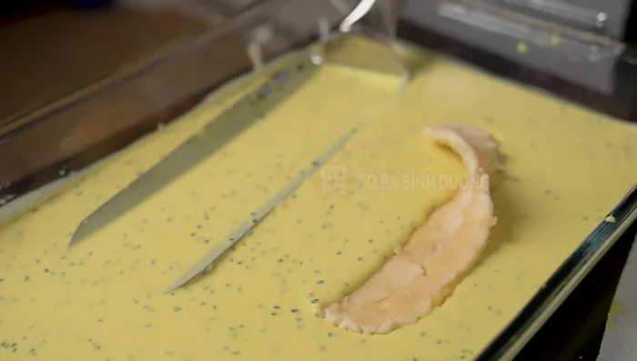 Coat the pressed bananas in the batter, ensuring even coverage.