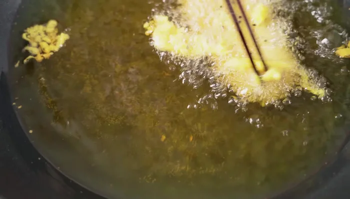Fry the bananas a second time, ensuring they puff up evenly by pouring oil over them or gently shaking the pan.
