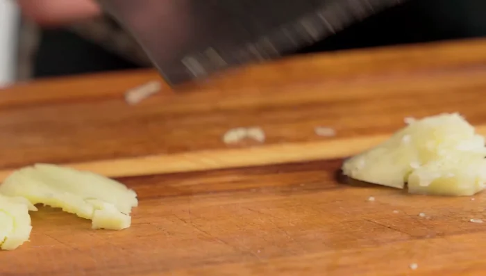 Prepare the aromatics: mince ginger, shallots, and lemongrass.