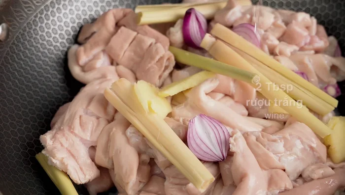 In a pan, stir-fry the intestines with ginger, shallots, lemongrass, and white wine for 5-7 minutes to remove excess water and fat. Discard the water.