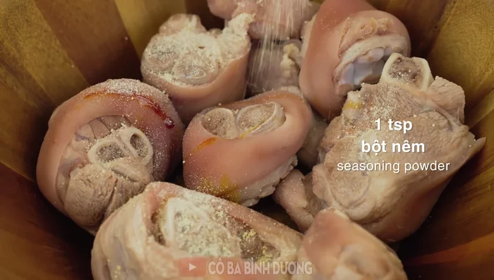 Marinate the pig's trotters with caramel, seasoning powder, soy sauce, fish sauce, sugar, and oil for 15-20 minutes.