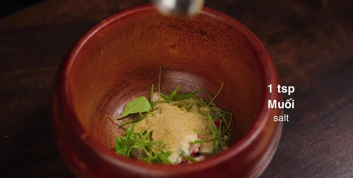 Prepare the marinade: In a mortar, puree shallots, chili, lemon leaves, seasoning powder, salt, and additional chili (optional). Add turmeric powder, pepper, cooking oil, and sugarcane juice. Mix well.