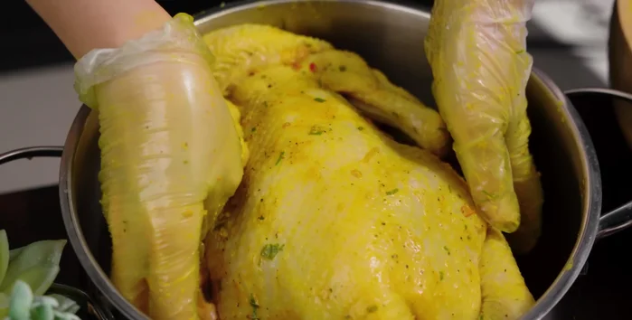 Steam the chicken: Place the chicken in the pot, add crushed lemon leaves on top, and pour in 150ml of sugarcane juice. Wrap the pot with aluminum foil, cover the lid, and steam over medium heat for about 50 minutes (adjust time depending on chicken weight).