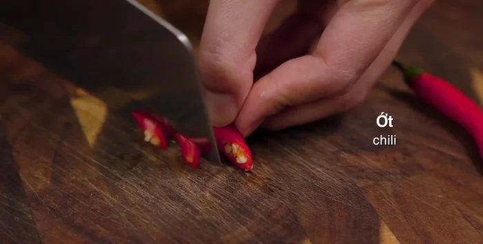 Prepare the ingredients: Slice shallots and chili. Crush ginger and mix with wine to clean the chicken and remove fishy smell. Cut lemongrass into strips and crush half of them. Split sugarcane.