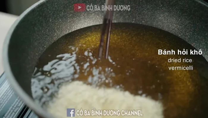 Fry the dry rice vermicelli until puffed up, turning it over quickly and using chopsticks to dip the cake into the oil to ensure even expansion. Take it out and tilt it on absorbent paper to drain the oil.