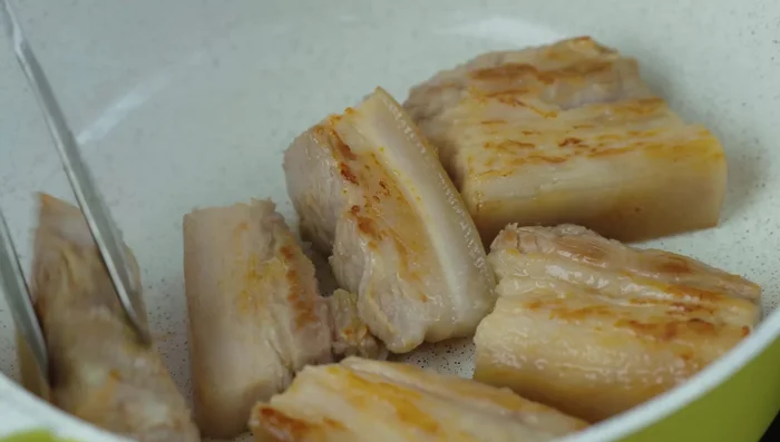 Transfer the pork belly to a pot. Add Coca-Cola, water, and fish sauce. Bring to a boil, skim off any foam.