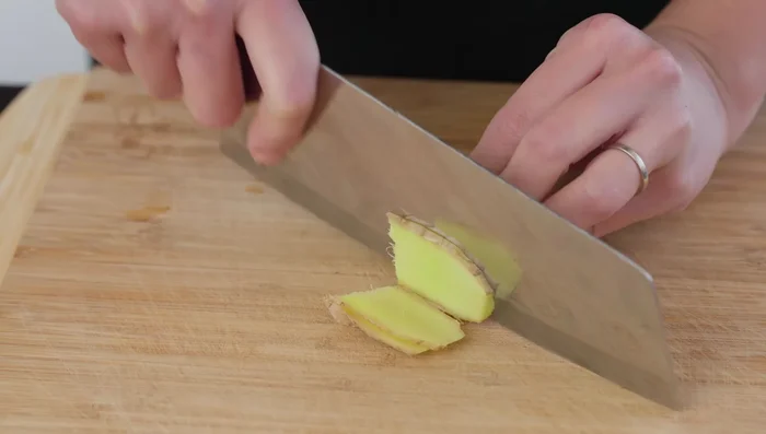 Cut the ginger into thin strips for marinating the fish.