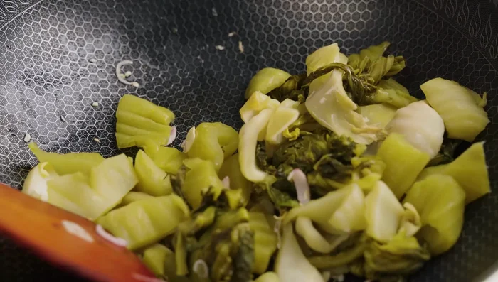 Add pickled cabbage, stir-fry over medium heat until fragrant, then season with seasoning powder, sugar, MSG (optional), chili sauce, fish sauce, and pepper. Stir-fry for about 2 minutes.
