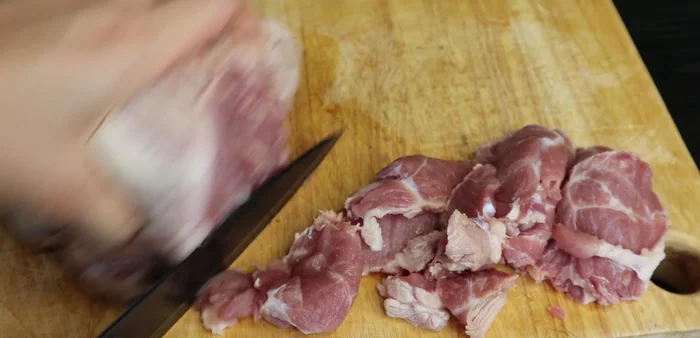 Thinly slice the blanched pork.