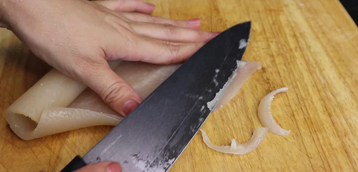 Cut the cooked pork skin thinly at a slight angle.