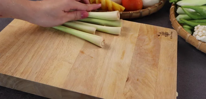 Prepare a wider pot. Add the pork bones, remaining crushed lemongrass, white radish (halved), onion (halved), cassava (halved), galangal, and pineapple.
