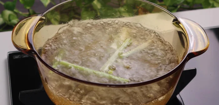 Add crushed lemongrass and salt, boil for 2 minutes. Remove bones and wash again.